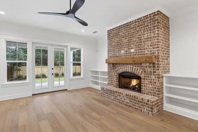 a living room with a fireplace and wooden floor