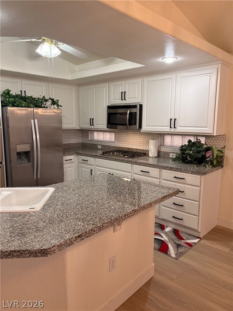 9040 Dove River Road Las Vegas, NV 89134 - Photo 6 of 22 Polished granite countertops and classic white cabinetry define this functional kitchen space.