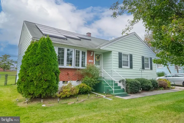 a front view of a house with a yard and potted plants
