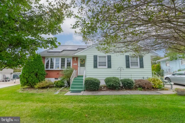 a front view of a house with a garden and plants