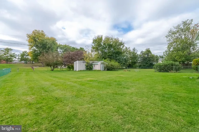a view of a house with a big yard and a large tree