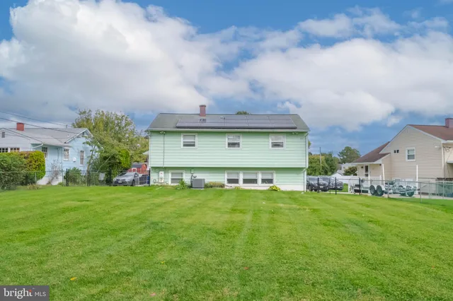 a view of a house with a big yard and large trees