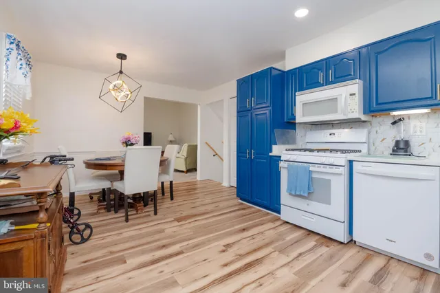 a kitchen with a table chairs a oven a stove and cabinets