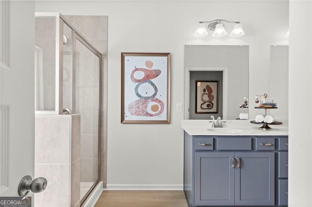 105 Roy Drive Calhoun, GA 30701 - Photo 26 of 28 a bathroom with a sink a mirror and a painting on the wall