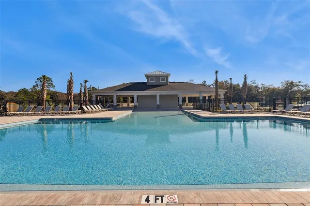 a view of a house with pool and chairs