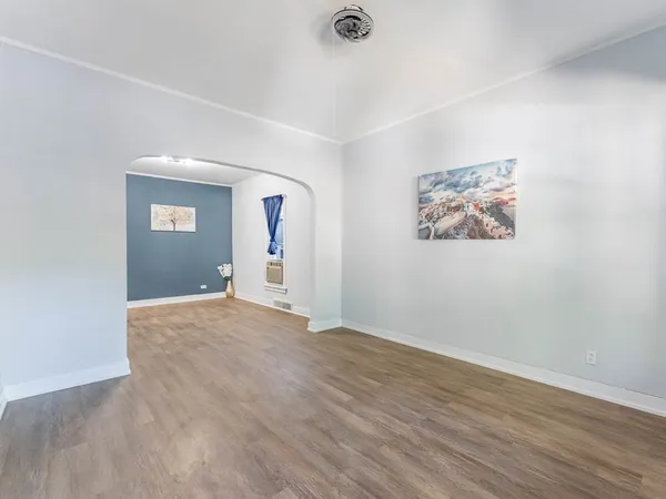an empty room with wooden floor and window