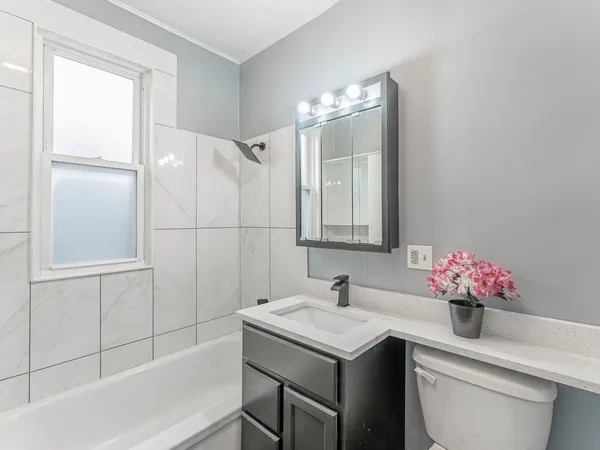 a bathroom with a sink and mirror with bathtub