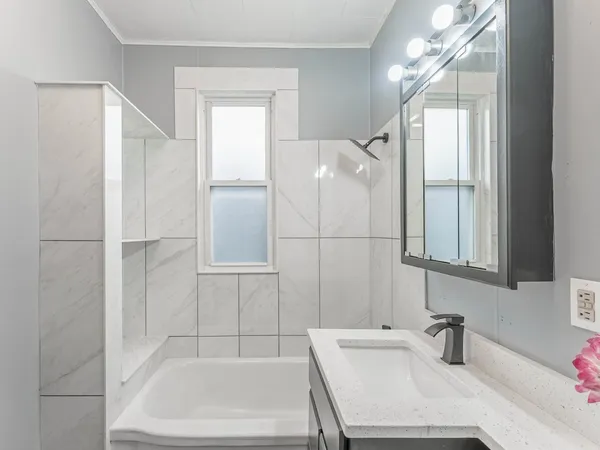 a bathroom with a sink a mirror and a bathtub