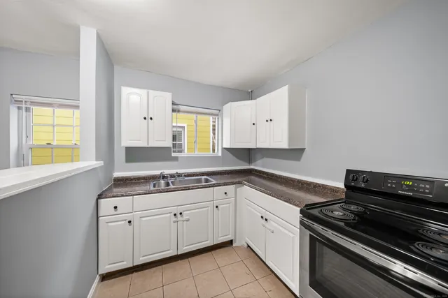 a kitchen with a stove a sink and a window