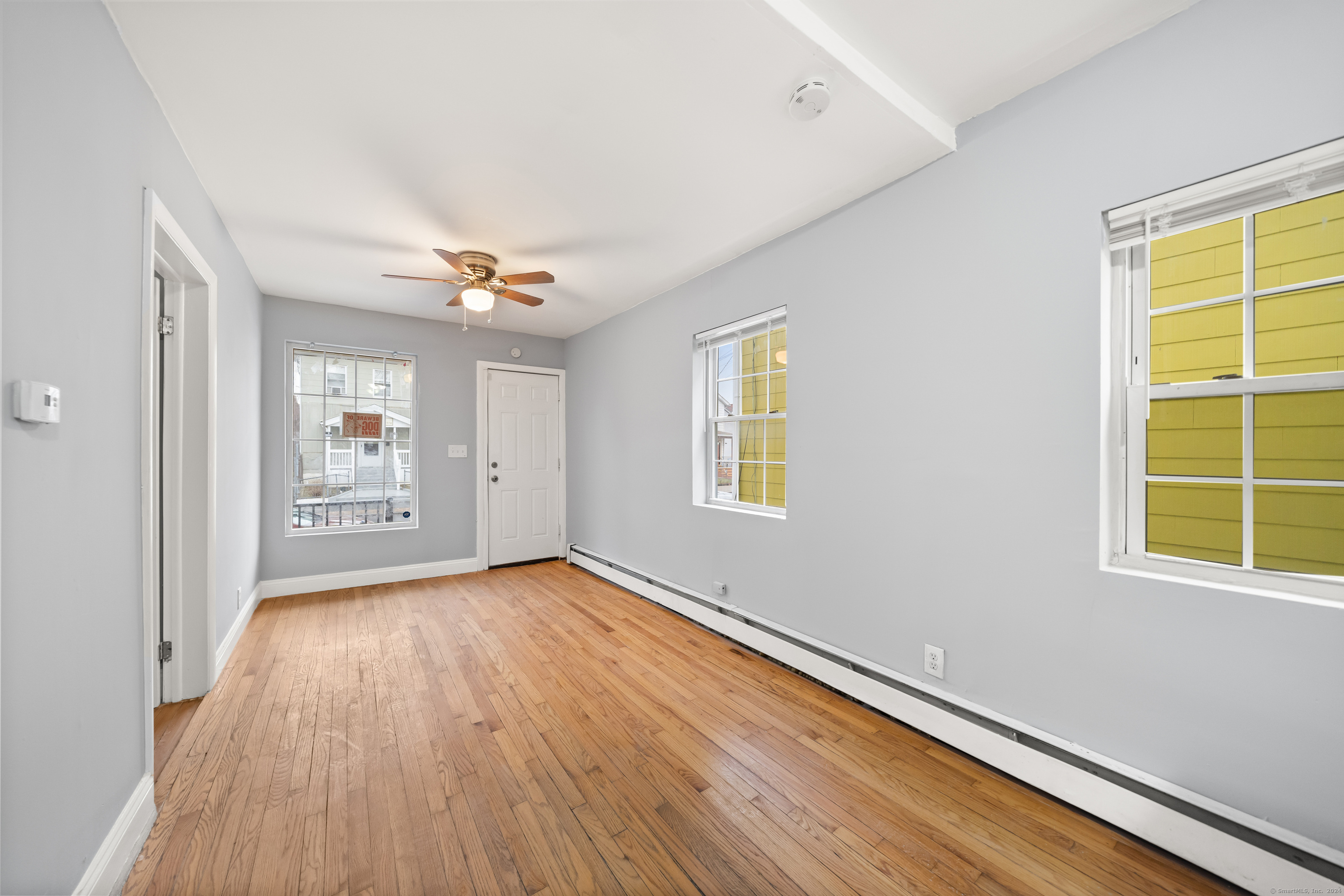 666 Ogden Street, Unit 1 Bridgeport, CT 06608 - Photo 4 of 10 a view of an empty room with a window and wooden floor