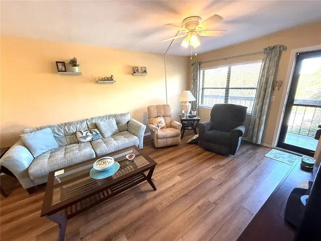 a living room with furniture ceiling fan and a window