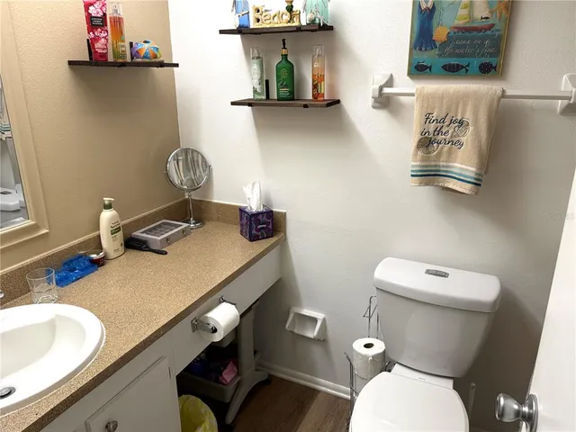 a bathroom with a granite countertop toilet and a sink