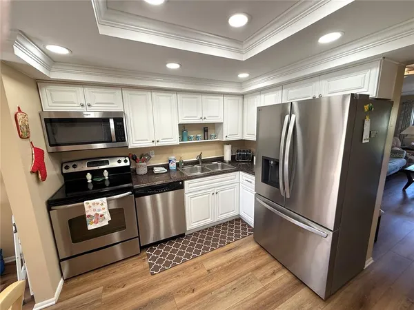 a kitchen with a refrigerator stainless steel appliances and cabinets