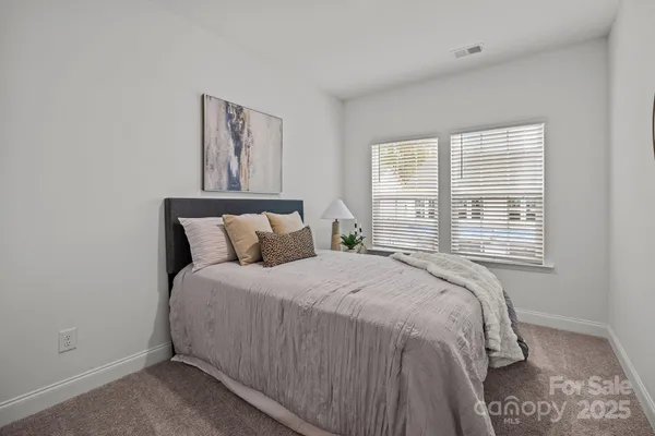 a large bed sitting in a bedroom next to a window