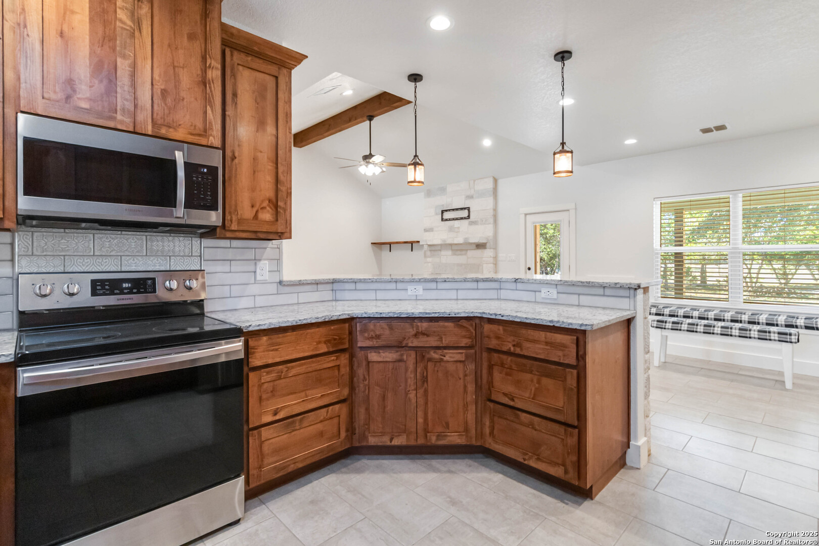 188 Old Camp Road Bandera, TX 78003 - Photo 11 of 36 a kitchen with stainless steel appliances granite countertop a stove a sink and a microwave