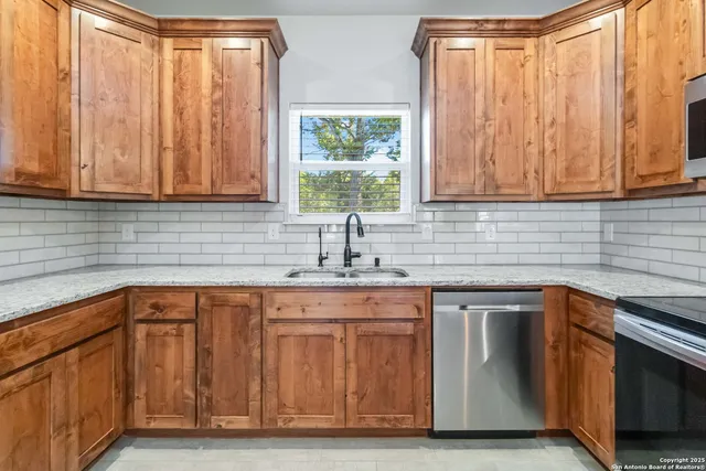 a kitchen with stainless steel appliances granite countertop a sink a microwave cabinets and a window