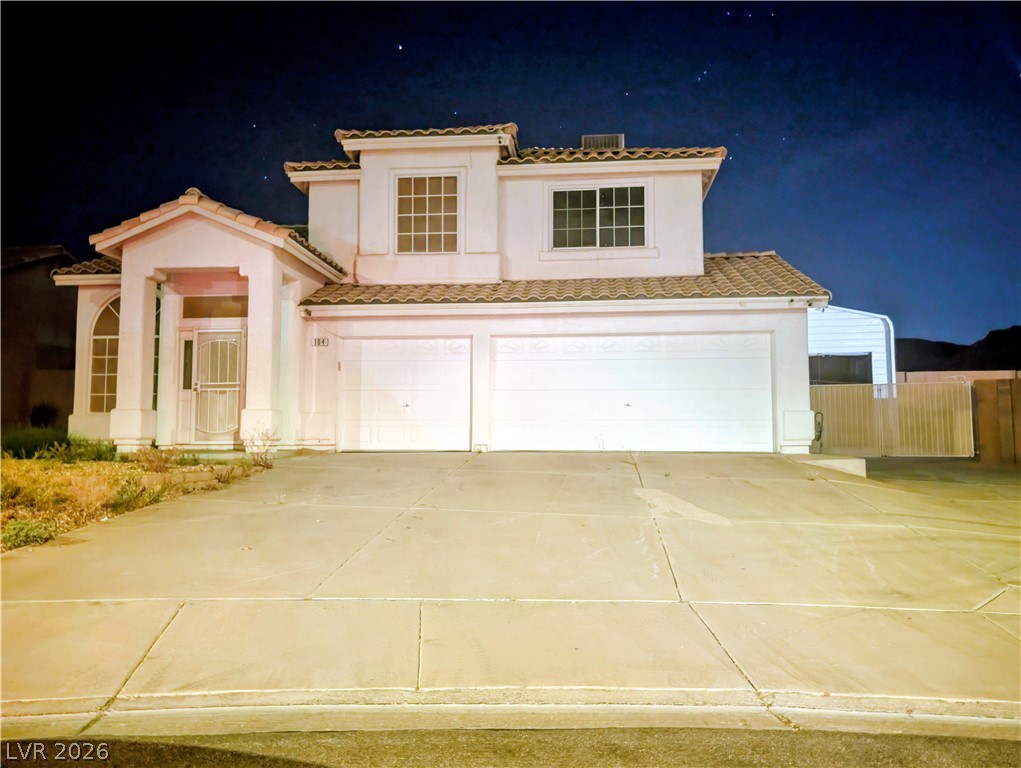 Mediterranean / spanish home featuring a garage, concrete driveway, stucco siding, and a tile roof