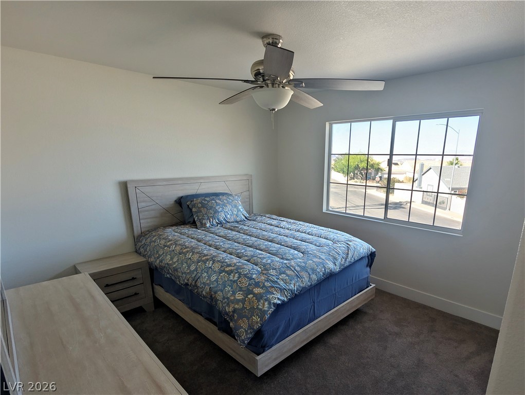 104 Appian Way Henderson, NV 89002 - Photo 11 of 37 Bedroom featuring dark carpet, a ceiling fan, and a textured ceiling