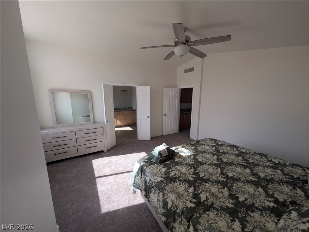 104 Appian Way Henderson, NV 89002 - Photo 14 of 37 Bedroom featuring lofted ceiling, dark carpet, ceiling fan, and ensuite bathroom