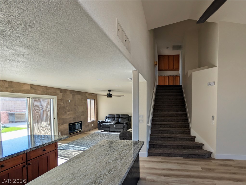 104 Appian Way Henderson, NV 89002 - Photo 18 of 37 Stairs featuring a ceiling fan, a fireplace, and wood finished floors