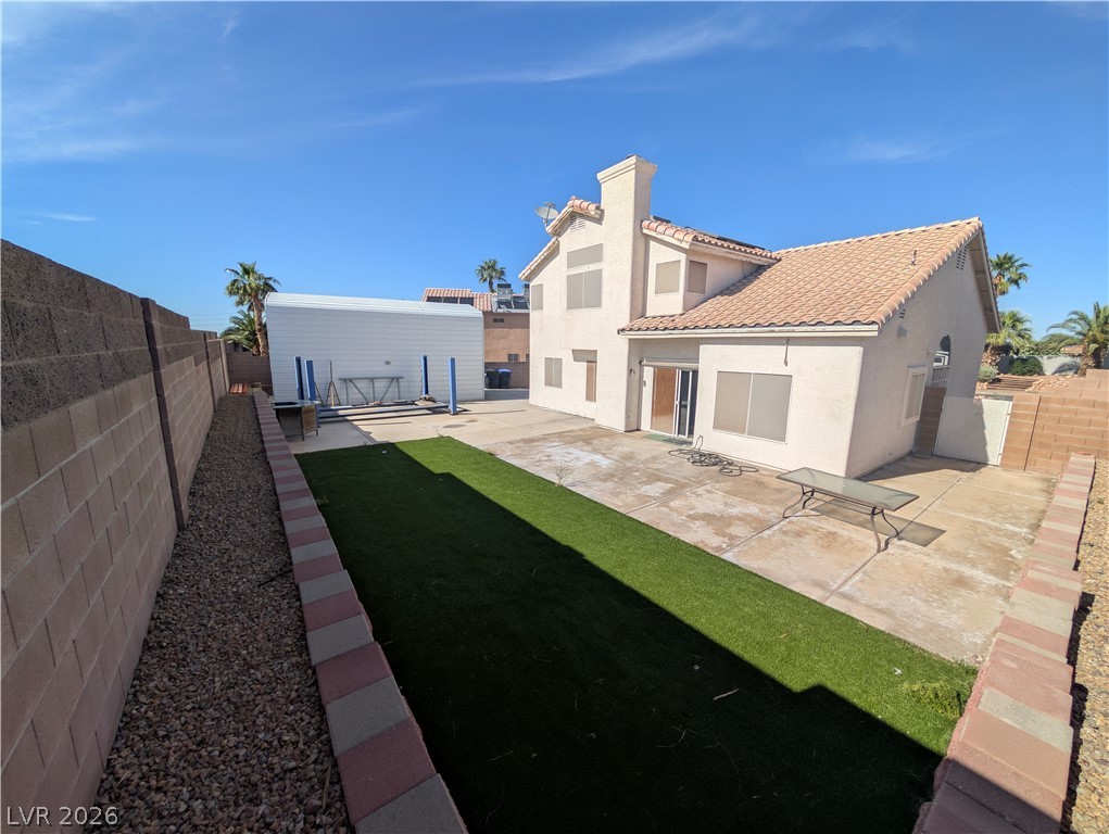 104 Appian Way Henderson, NV 89002 - Photo 23 of 37 Back of property with a patio, a fenced backyard, stucco siding, an outbuilding, and a tile roof