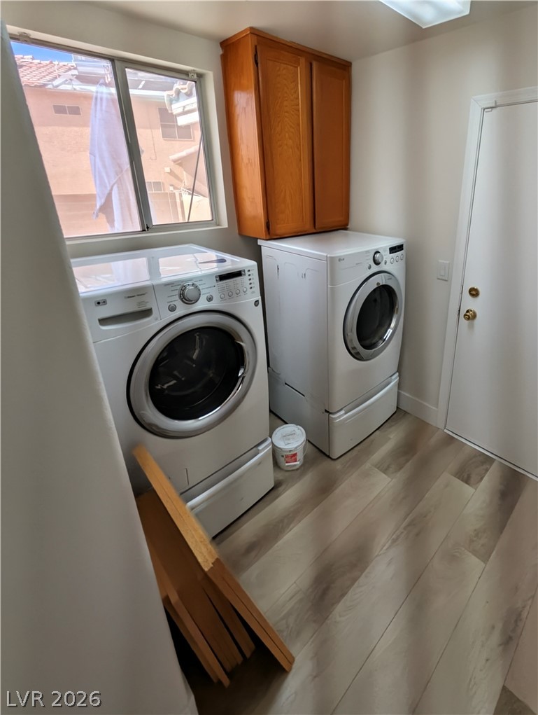 104 Appian Way Henderson, NV 89002 - Photo 34 of 37 Laundry room featuring cabinet space, light wood-style flooring, and washing machine and dryer