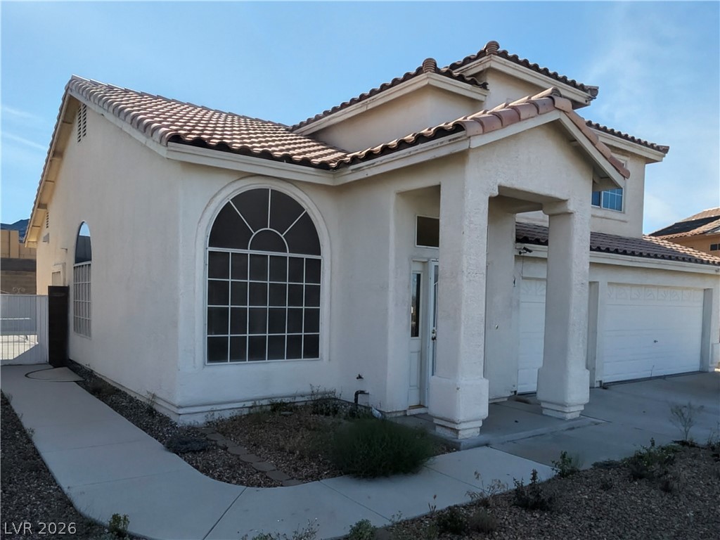 104 Appian Way Henderson, NV 89002 - Photo 4 of 37 Mediterranean / spanish house with stucco siding, a tiled roof, a gate, and concrete driveway