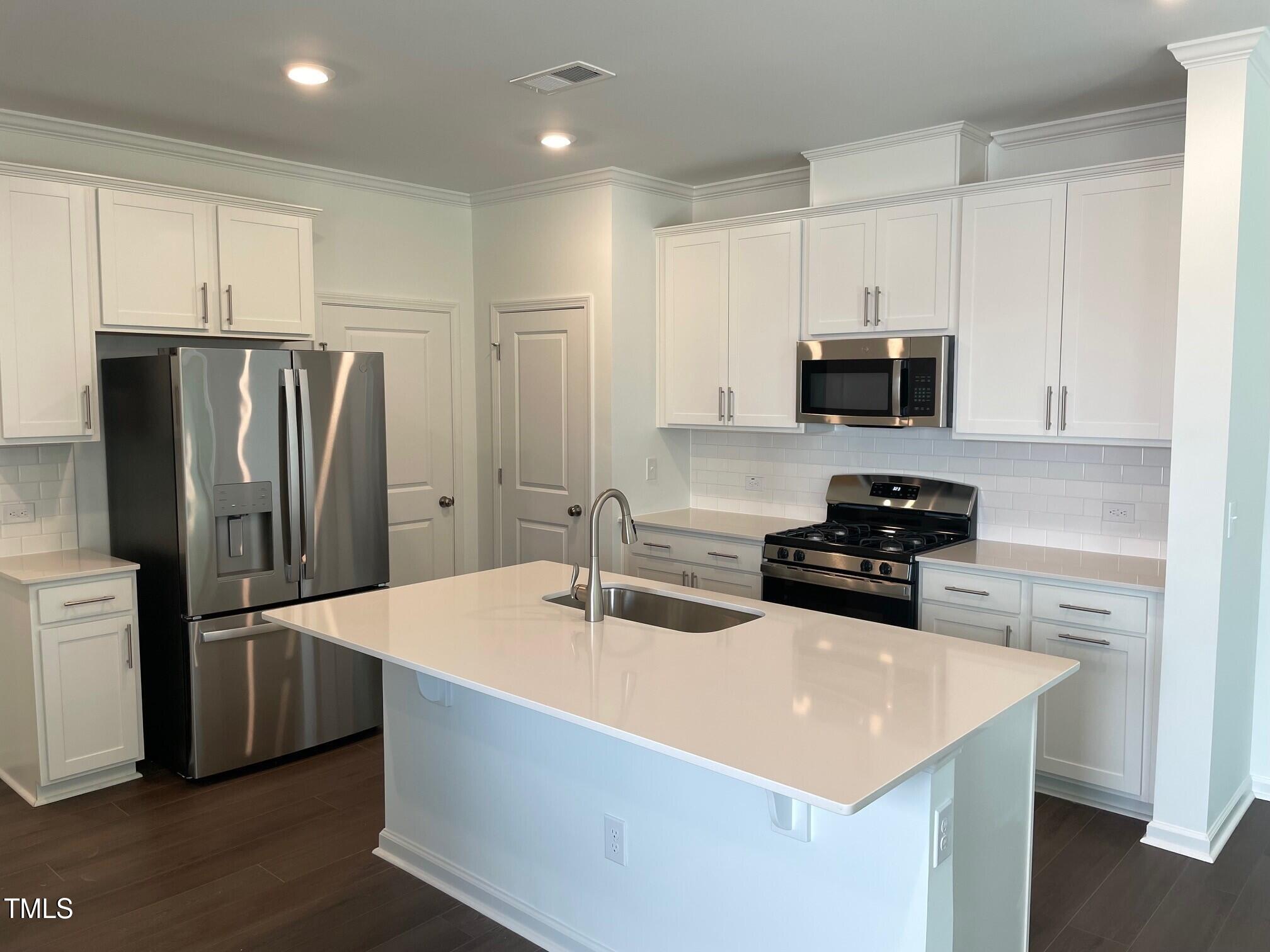 3019 Vitner Drive Durham, NC 27704 - Photo 11 of 20 a kitchen with stainless steel appliances a sink a stove a refrigerator and cabinets