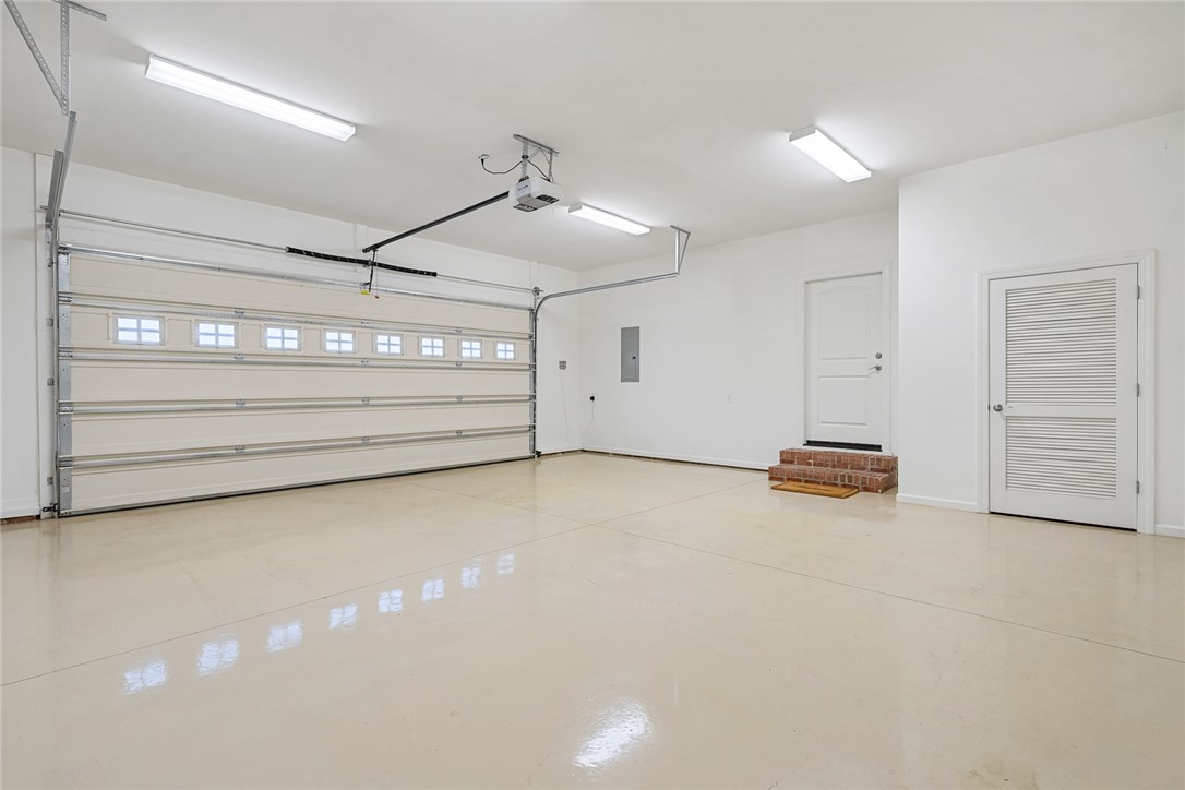 16 Oleander Drive Anderson, SC 29621 - Photo 33 of 37 A spacious, well-lit garage features a gleaming epoxy floor, offering both durability and appeal.