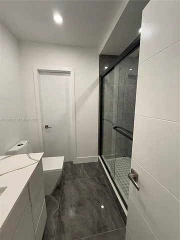 a bathroom with a sink a toilet a shower and a mirror