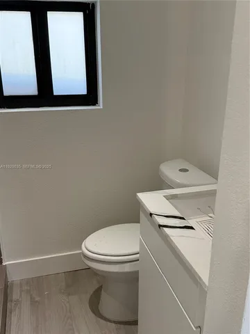a white toilet sitting next to a white wall