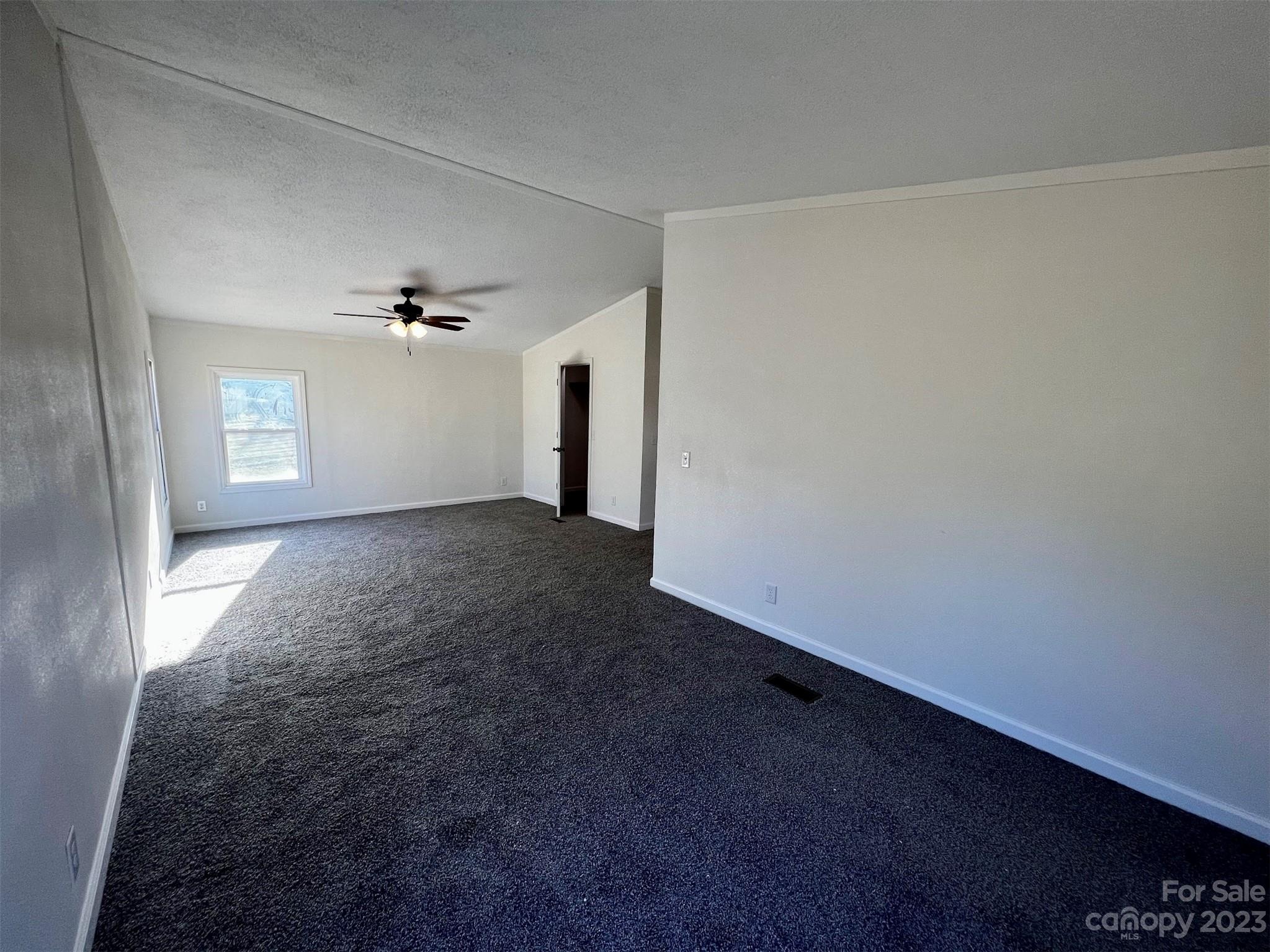 570 Scottdale Road Canton, NC 28716 - Photo 13 of 44 an empty room with windows and chandelier fan
