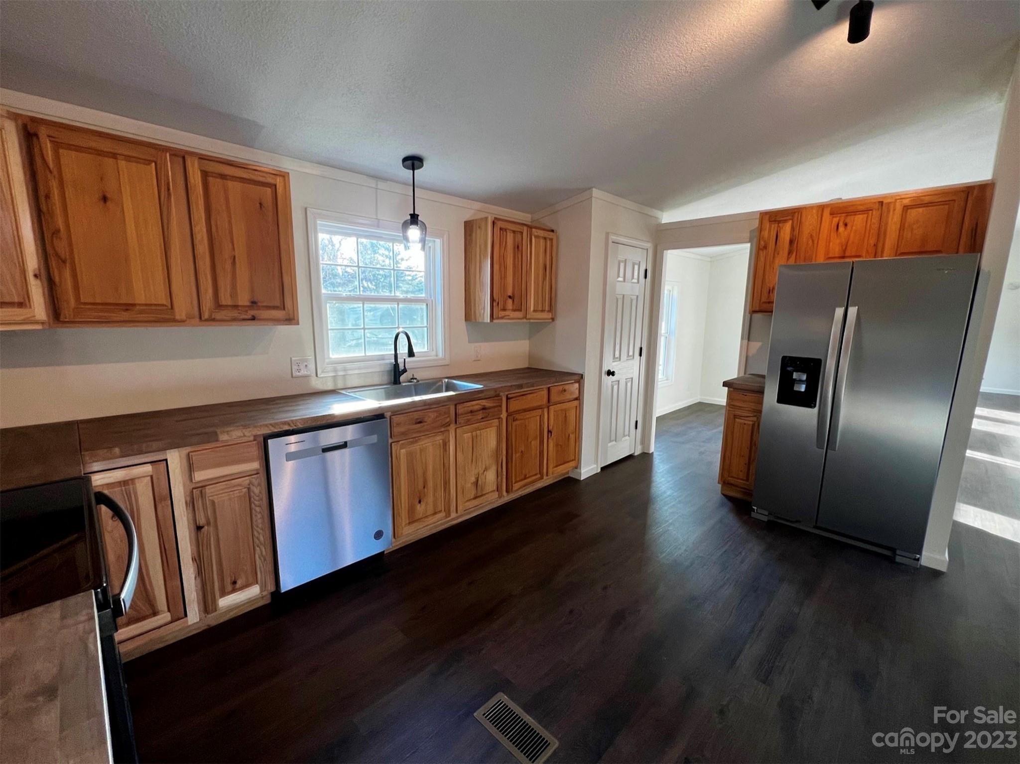 570 Scottdale Road Canton, NC 28716 - Photo 4 of 44 a kitchen with stainless steel appliances granite countertop a refrigerator a sink dishwasher a stove and wooden floor next to a window