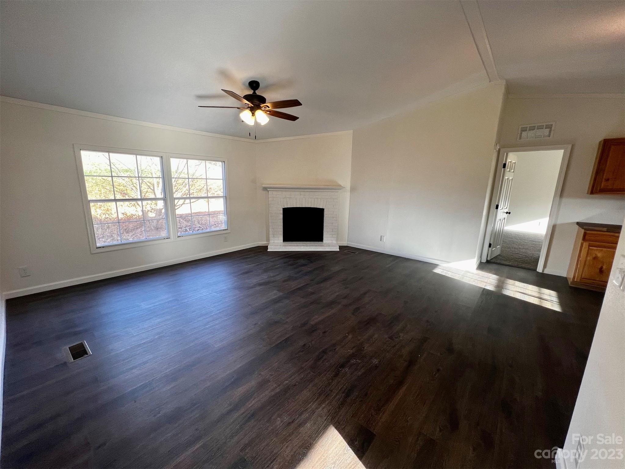 570 Scottdale Road Canton, NC 28716 - Photo 10 of 44 a view of a livingroom with wooden floor a ceiling fan and a window