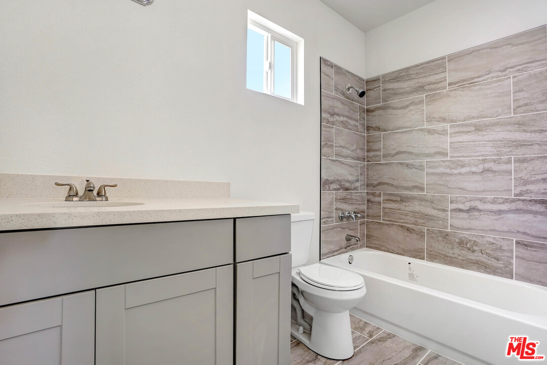 7595 Emerald Street Riverside, CA 92504 - Photo 14 of 14 a bathroom with a bathtub shower sink mirror and toilet