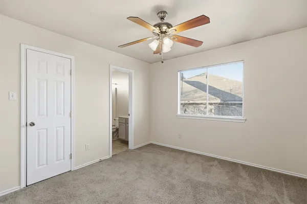 an empty room with window and ceiling fan