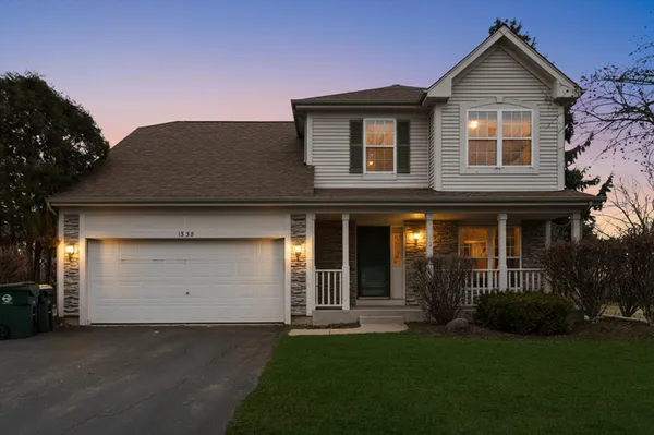 a front view of a house with a garden and yard