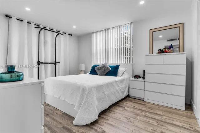 a bedroom with a bed painting on wall and a window