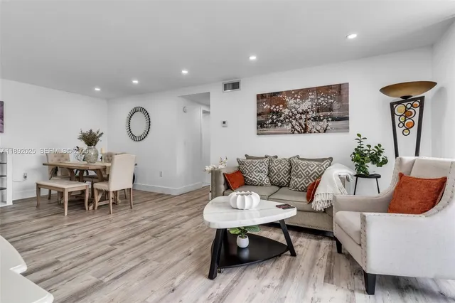 a living room with furniture and a wooden floor
