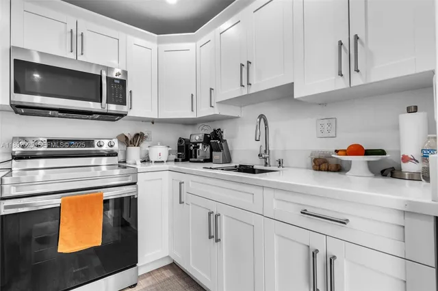 a kitchen with white cabinets and appliances