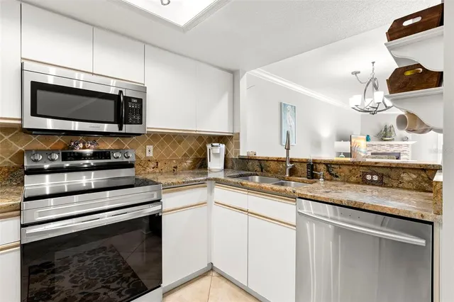 a kitchen with stainless steel appliances granite countertop a sink stove and microwave