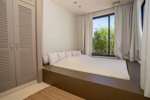 a bedroom with a bed and a lamp with the view of bathroom