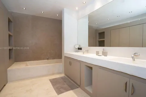 a large bed sitting in a bedroom next to a window