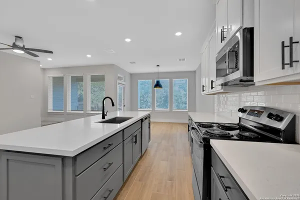 a kitchen with stainless steel appliances granite countertop a sink stove and microwave