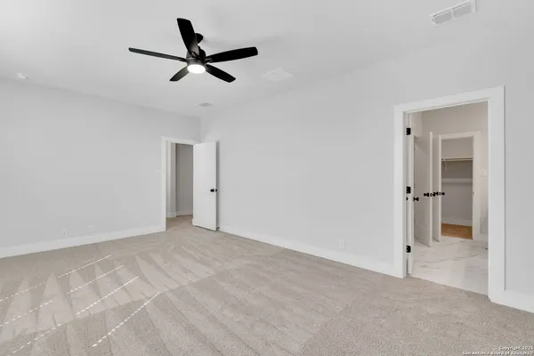 a view of room with ceiling fan and windows