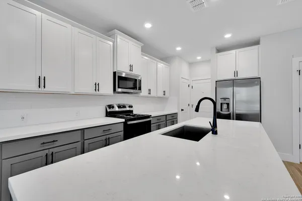 a kitchen with stainless steel appliances a sink microwave and cabinets