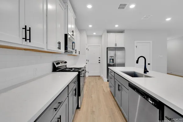 a kitchen with sink a stove and cabinets