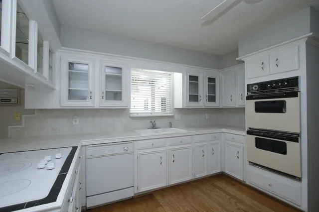 a kitchen with a sink a microwave and cabinets