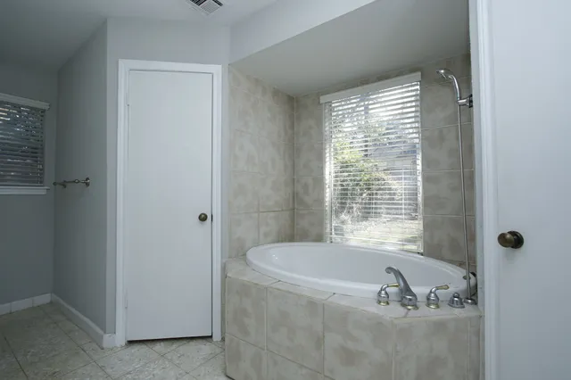 a bath tub sitting in a bathroom next to a window