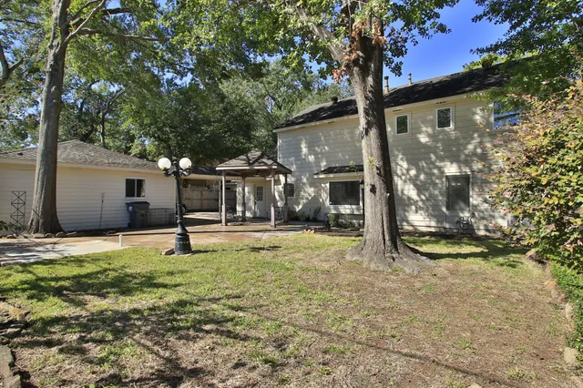 a backyard of a house with barbeque oven and trees